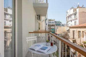 Un balcón con una mesa y un libro. en Trikoupi 95 by ABR, en Atenas
