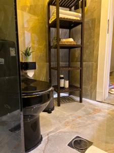ein Bad mit einem schwarzen WC in einem Zimmer in der Unterkunft شقة فاخرة في حطين in Riad