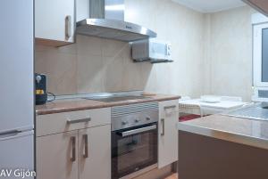 a kitchen with white cabinets and a stove top oven at AV Gijón Manso 20 in Gijón