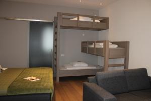 a bedroom with a bunk bed and a couch at Hotel 't Peperhuys in Kaatsheuvel