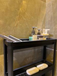 شقة فاخرة بإطلالة قريبة من البوليفارد في الرياض: منضدة الحمام مع المجلى صابون وزجاجين