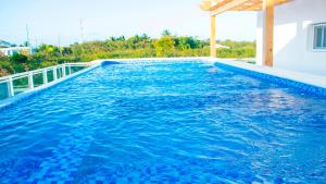 a swimming pool with blue water in a house at Hotel Capriccio Mare y Restaurante in Punta Cana