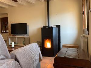 a living room with a stove with a fire in it at Casa Montanyés in Conques