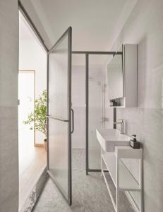 a bathroom with a glass shower and a sink at M Village Nguyễn Du in Ho Chi Minh City