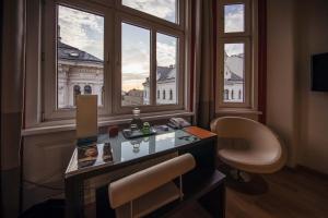 een kamer met een bureau en een raam met uitzicht op een gebouw bij Hotel Rathaus - Wein & Design in Wenen