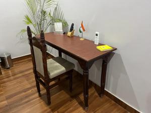 una mesa de madera con una silla en una habitación en Colonel's Abode en Agra