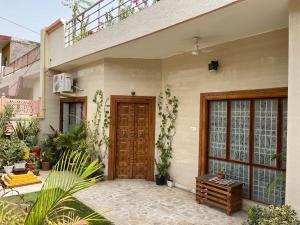 dom z drewnianymi drzwiami i roślinami w obiekcie Colonel's Abode w mieście Agra