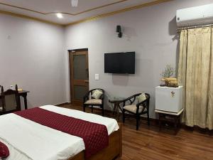 a bedroom with a bed and a tv on the wall at Colonel's Abode in Agra