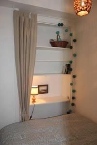 ein Schlafzimmer mit einem Fenster mit einem Vorhang und einer Lampe in der Unterkunft Escapade romantique et gourmande-St Malo, mer 150m in Saint-Malo