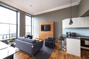 a living room with a couch and a tv at JOIVY Chic 2BR Apt with City Views at the Heart of Old Town in Edinburgh
