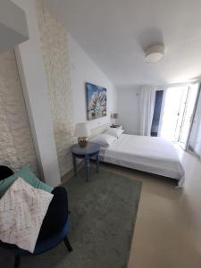 a large white bedroom with a bed and a table at Apartment Milena in Drasnice