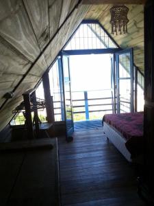 Habitación con cama y ventana grande. en Casa de praia na beira do mar, en Florianópolis