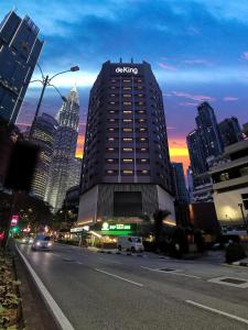 a building with a sign on it on a city street at de King Hotel KLCC in Kuala Lumpur