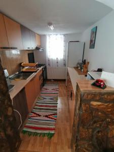 a kitchen with wooden cabinets and a rug on the floor at Cabana Daria in Gârda de Sus