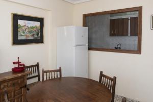 uma cozinha com uma mesa e um frigorífico branco em Apolo, 5º- 30 em Cullera