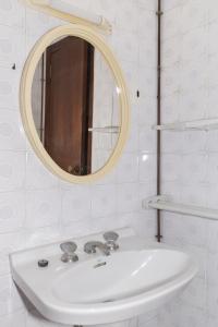 uma casa de banho com um lavatório branco e um espelho. em Apolo, 5º- 30 em Cullera