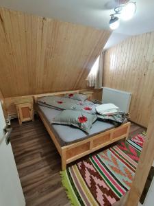 a bed in a room with a wooden ceiling at Cabana Daria in Gârda de Sus