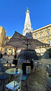 a group of tables and chairs in front of a tower at Famme sta cuiete appartamento Napoli centro in Naples