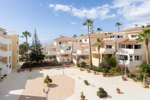 an apartment complex with palm trees and buildings at Home2Book Chayofa Sunny Terrace & Pool in Arona