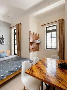 1 dormitorio con mesa de madera y 1 cama en Da Lat Lemongrass - Đà Lạt Sả en Dalat