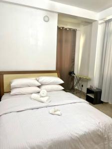 One Room Private Apartment في هولهومالي: غرفة نوم بسرير ابيض عليها مناشف
