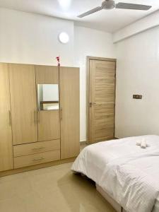 One Room Private Apartment في هولهومالي: غرفة نوم بسرير كبير ودواليب خشبية