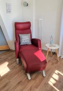 una silla roja con una almohada sobre una mesa en SchönZeit, en Limburg an der Lahn