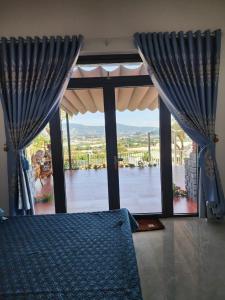 Namban的住宿－OVi farmstay Nam Ban - Lâm Hà，一间卧室配有蓝色窗帘和大窗户