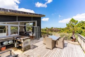 patio con tavolo e sedie su una terrazza di Manuka Sanctuary - Mangawhai Heads Holiday Home a Mangawhai