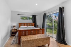 una camera con un letto e una grande finestra di Manuka Sanctuary - Mangawhai Heads Holiday Home a Mangawhai