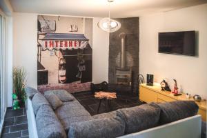 Gîte de L´ô d´Or في Villers-devant-Orval: غرفة معيشة مع أريكة وتلفزيون