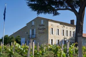 un bâtiment avec un panneau sur son côté dans l'établissement Château Bonalgue - Pomerol, à Libourne