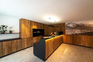 een woonkamer met houten lambrisering en een open haard bij Les Ciases Chalets Dolomites Apt 2 in San Vigilio Di Marebbe