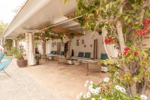 an outdoor patio with chairs and a tree at Bahía de Alcudia Hotel & Spa in Port d'Alcudia