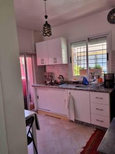 a kitchen with white cabinets and a sink at proche aéroport, idéal pour travailler in Marrakesh +4 photos