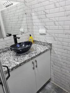 baño con lavabo negro en la encimera en Pied à terre proche aéroport, en Marrakech