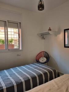 1 dormitorio con 1 cama y reloj en la pared en Pied à terre proche aéroport, en Marrakech