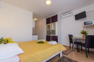 a bedroom with a bed and a table and a desk at Apartments Mijo in Trogir