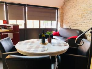 ein Tisch und Stühle mit einer Flasche Wein drauf in der Unterkunft L'Aubergiste in Corcelles-les-Arts