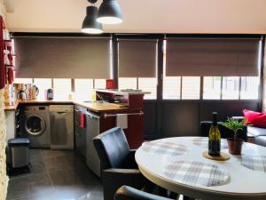 a kitchen with a table and a kitchen with a table and chairs at L'Aubergiste in Corcelles-les-Arts