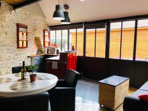 a room with a table and chairs and a counter at L'Aubergiste in Corcelles-les-Arts