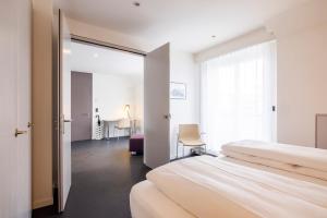 una camera d'albergo con due letti e una finestra di EMA House Serviced Apartments Seefeld a Zurigo