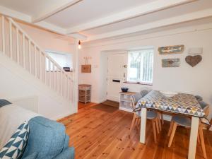 a living room with a table and a staircase at Little Barn Cottage in Newport Pembrokeshire