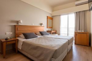 1 dormitorio con cama grande y ventana grande en City Plus Rhodes Hotel, en Rodas