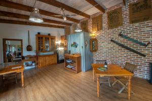 un soggiorno con tavoli in legno e un muro di mattoni di At the Woods Guest House a Stormsrivier