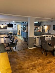 um restaurante com mesas e cadeiras e um bar em Newcastle Arms Hotel em Coldstream