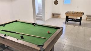 a snooker table in a room with a pool at Casa din Vie, Piscină Încălzită, întreaga locație la 15min de centrul orașului Oradea in Oradea