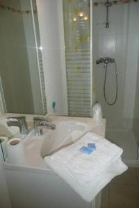 ein Bad mit einem Waschbecken, einer Dusche und einem Handtuch in der Unterkunft Gîtes des Isles - Le Jersey in Barneville-Carteret