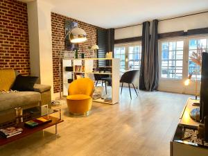 a living room with a couch and a dining room at Appartement Héloïse, le charme du Vieux-Lille in Lille
