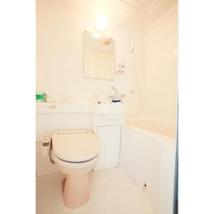 a white bathroom with a toilet and a bath tub at Smile Hotel Asakusa in Tokyo